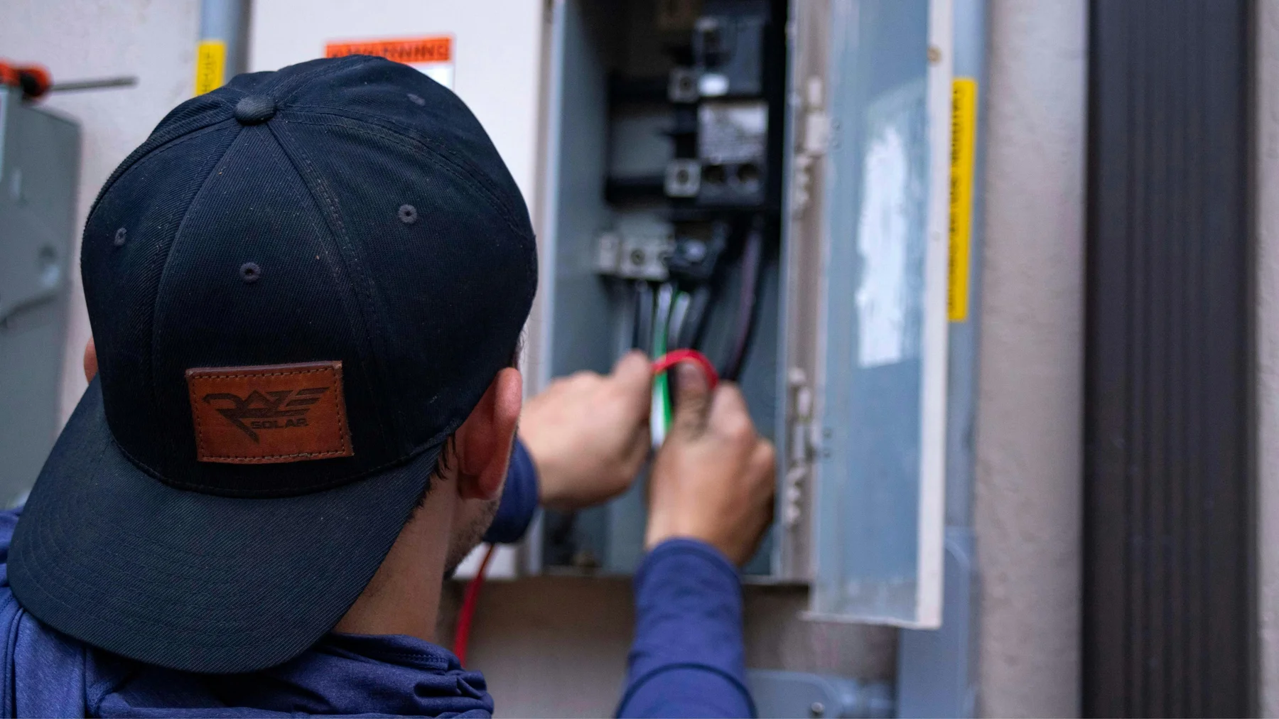 Electrician working at electrical service equipment — stock photograph